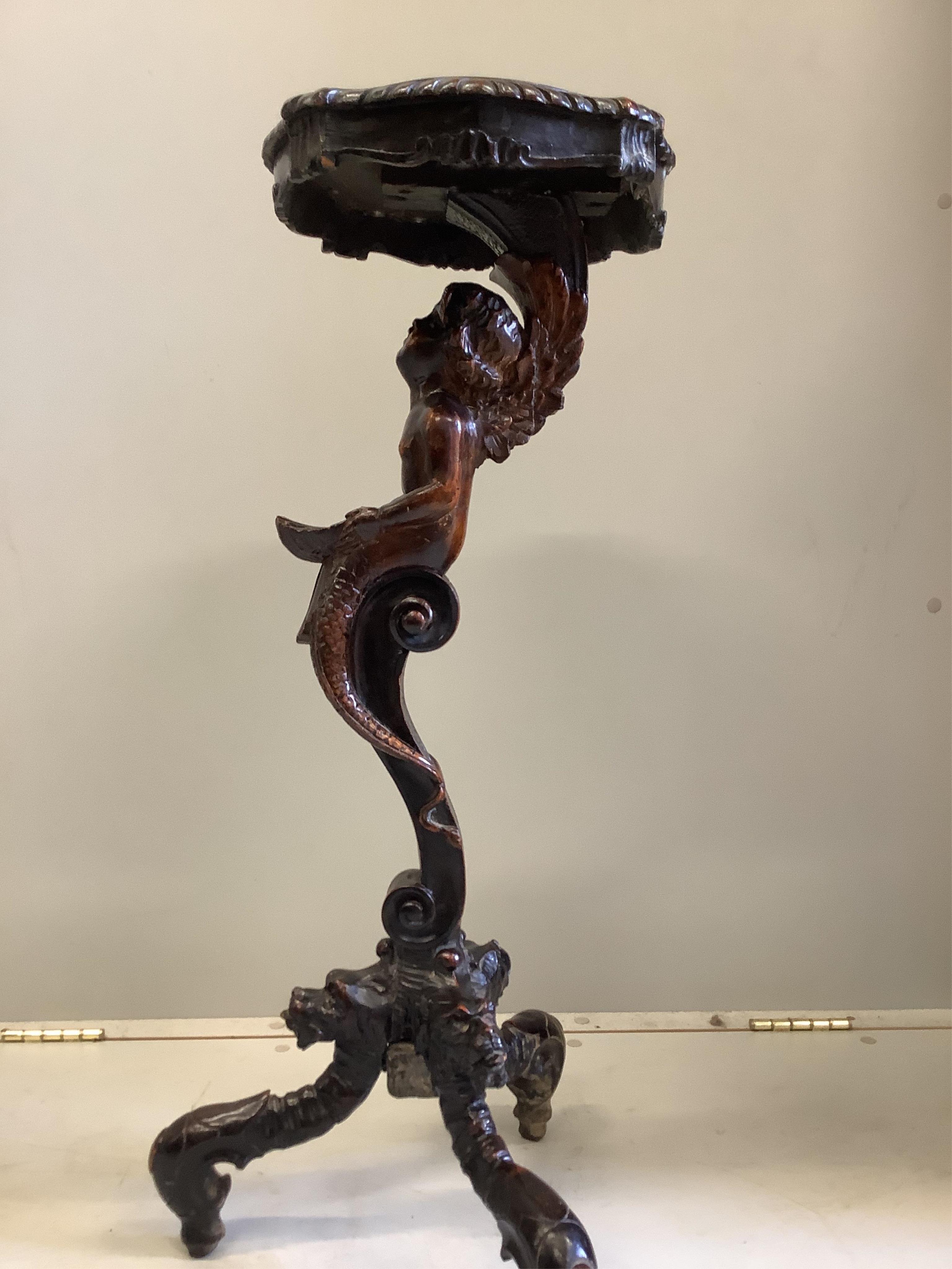 An Italian carved walnut cherub and shell torchere, height 81cm. Condition - good